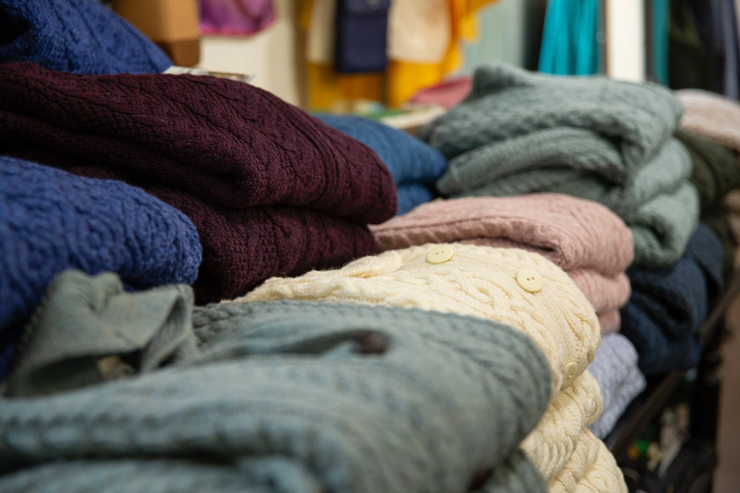 Folded knitwear in burgundy, blue, cream, pink and sage displayed at The Irish Shop in Skippack, Pennsylvania.