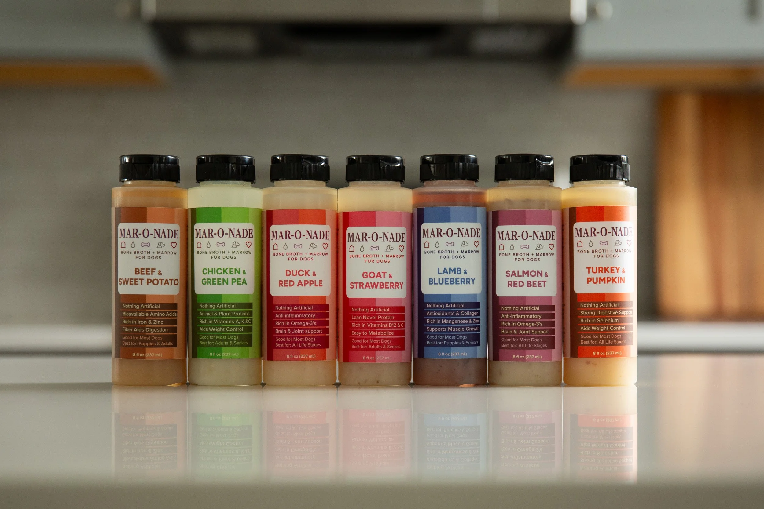 Collection of Mar-O-Nade dog broth bottles photographed together on a kitchen counter.