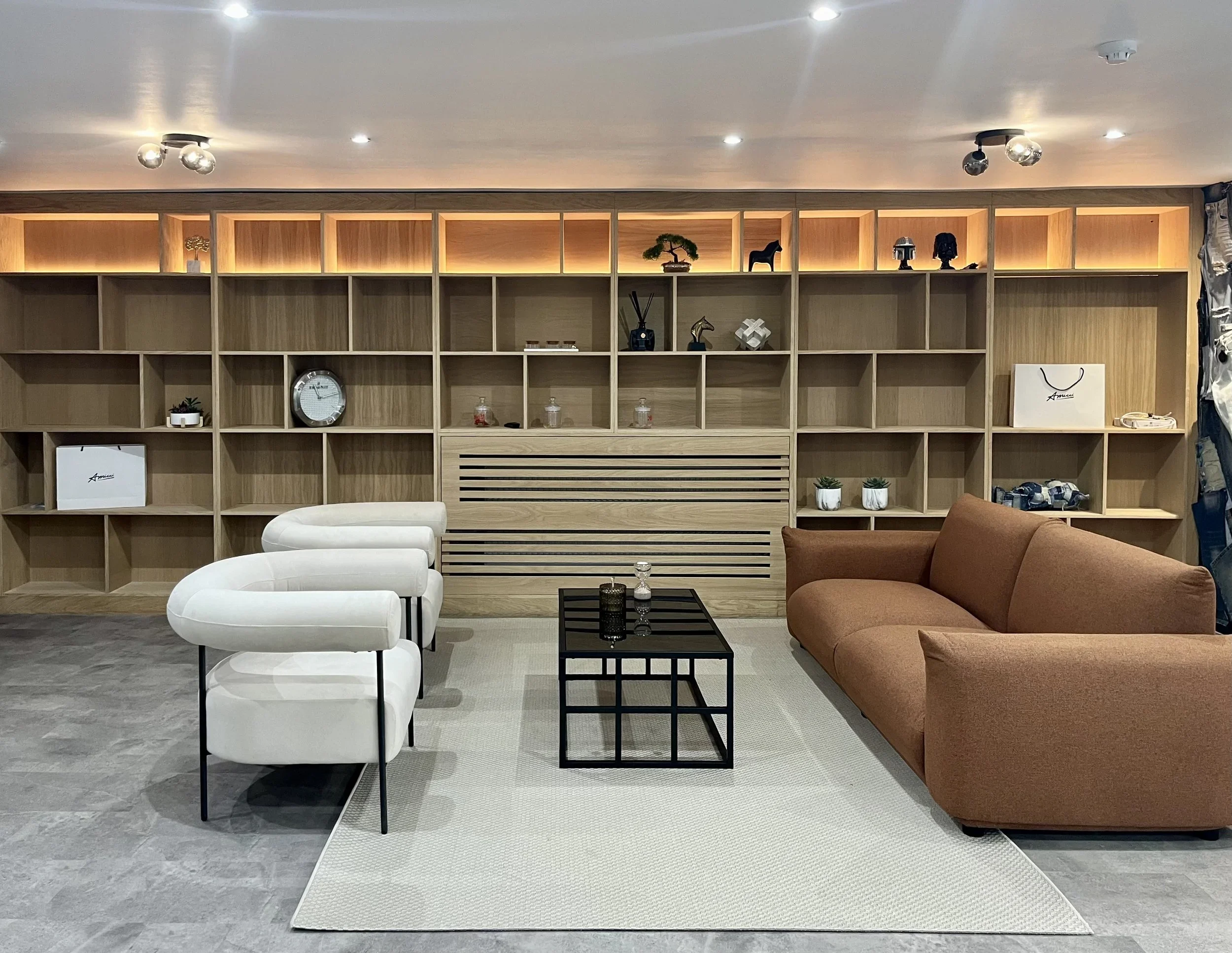 This custom fitted shelving unit combines open display shelving, integrated storage and warm LED lighting to create a statement feature wall that is both practical and visually striking.
