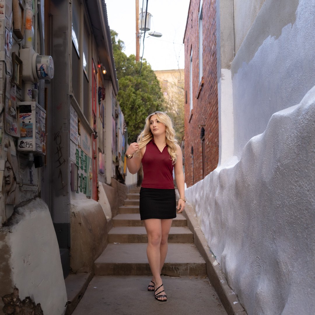 Female Graduate walking in alley in Bisbee, Arizona in the spring for a graduation photo session