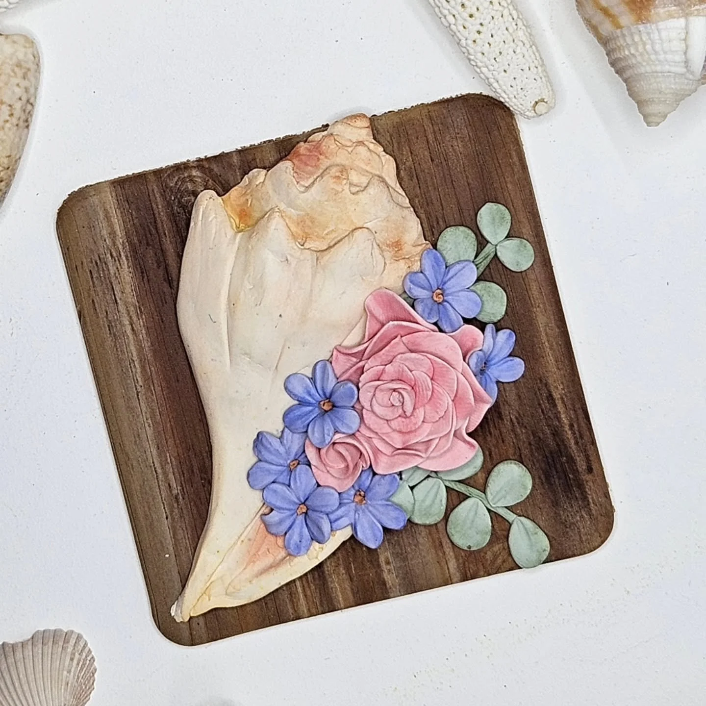 Sharing another small art piece.  3x3" conch shell with flowers. Most of the time I keep my clay tiles as is, maybe add a clay frame or border, but this one I decided to mount on a shadow box frame.

I am on the search for small shadow box frame