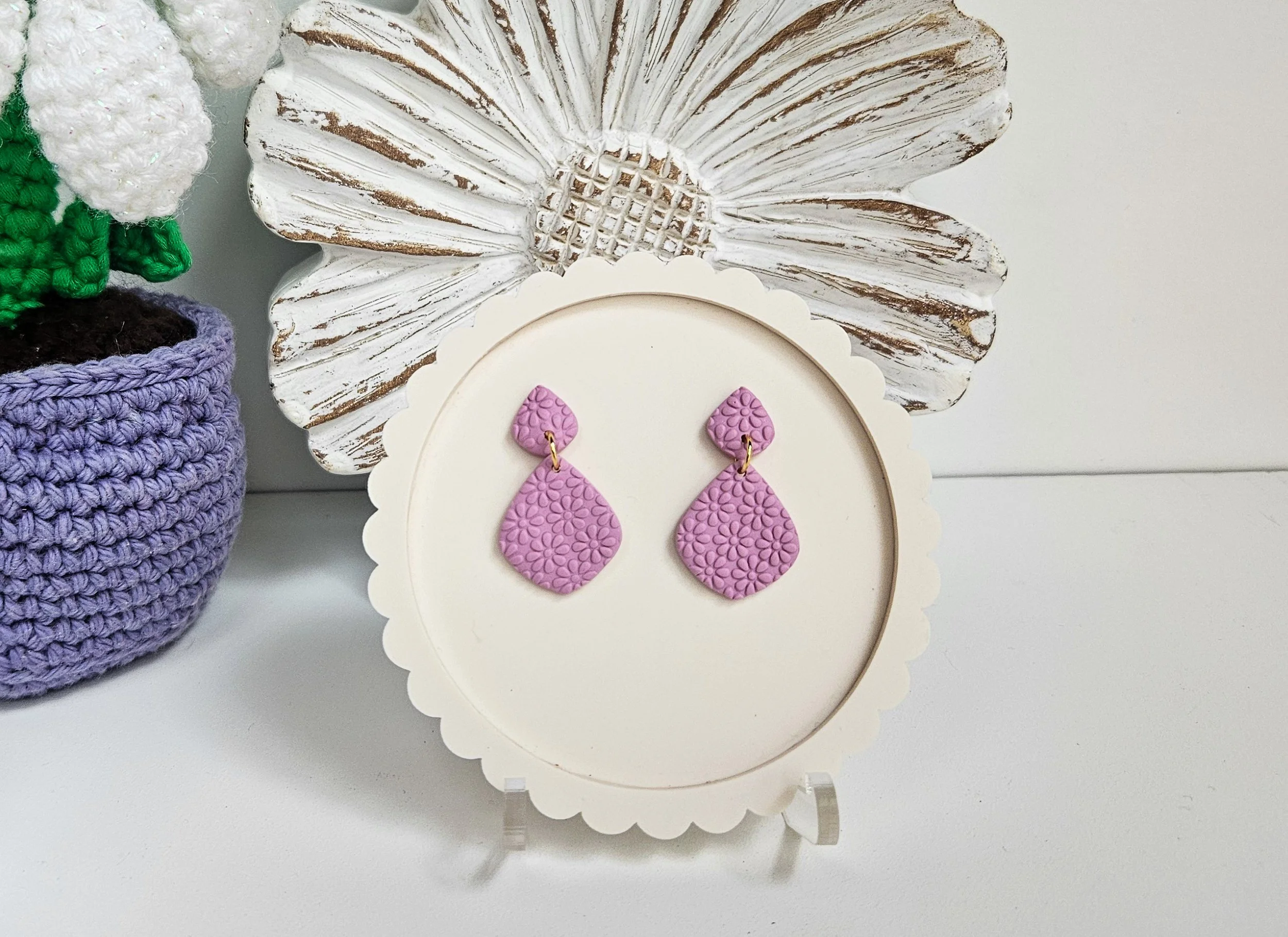 Elegant mauve-colored drop earrings featuring delicate floral patterns, handcrafted from polymer clay.