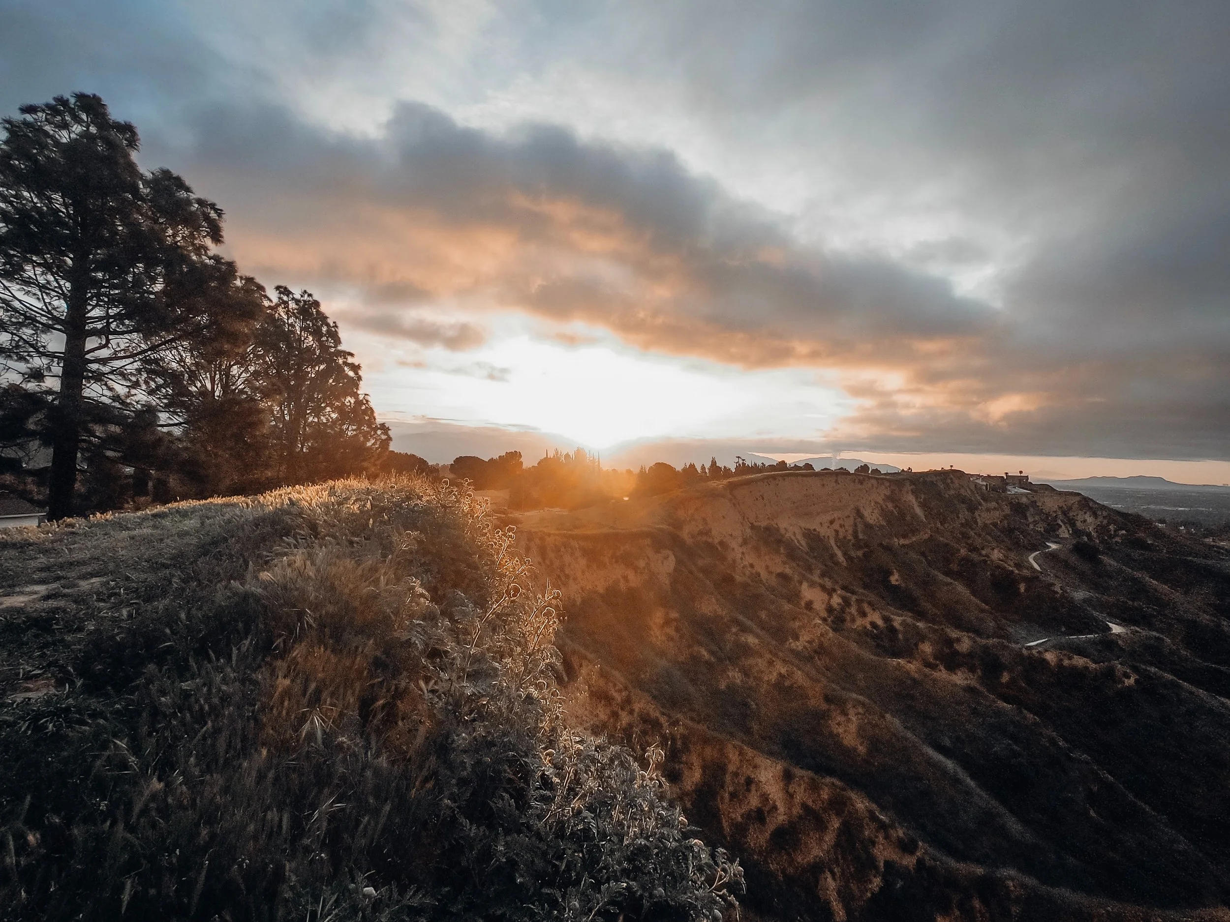 copper-hued clouds and hilltop at sunset