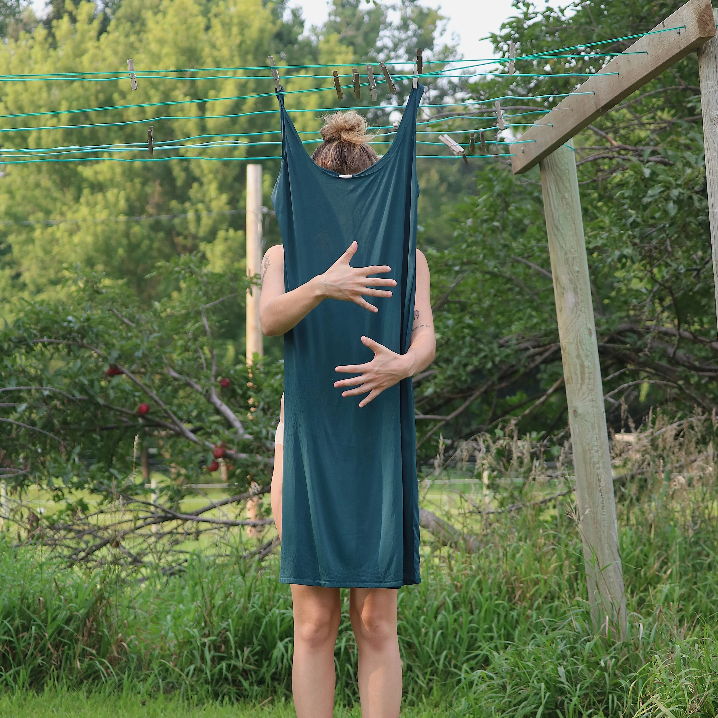 Woman hugging dress on laundry line