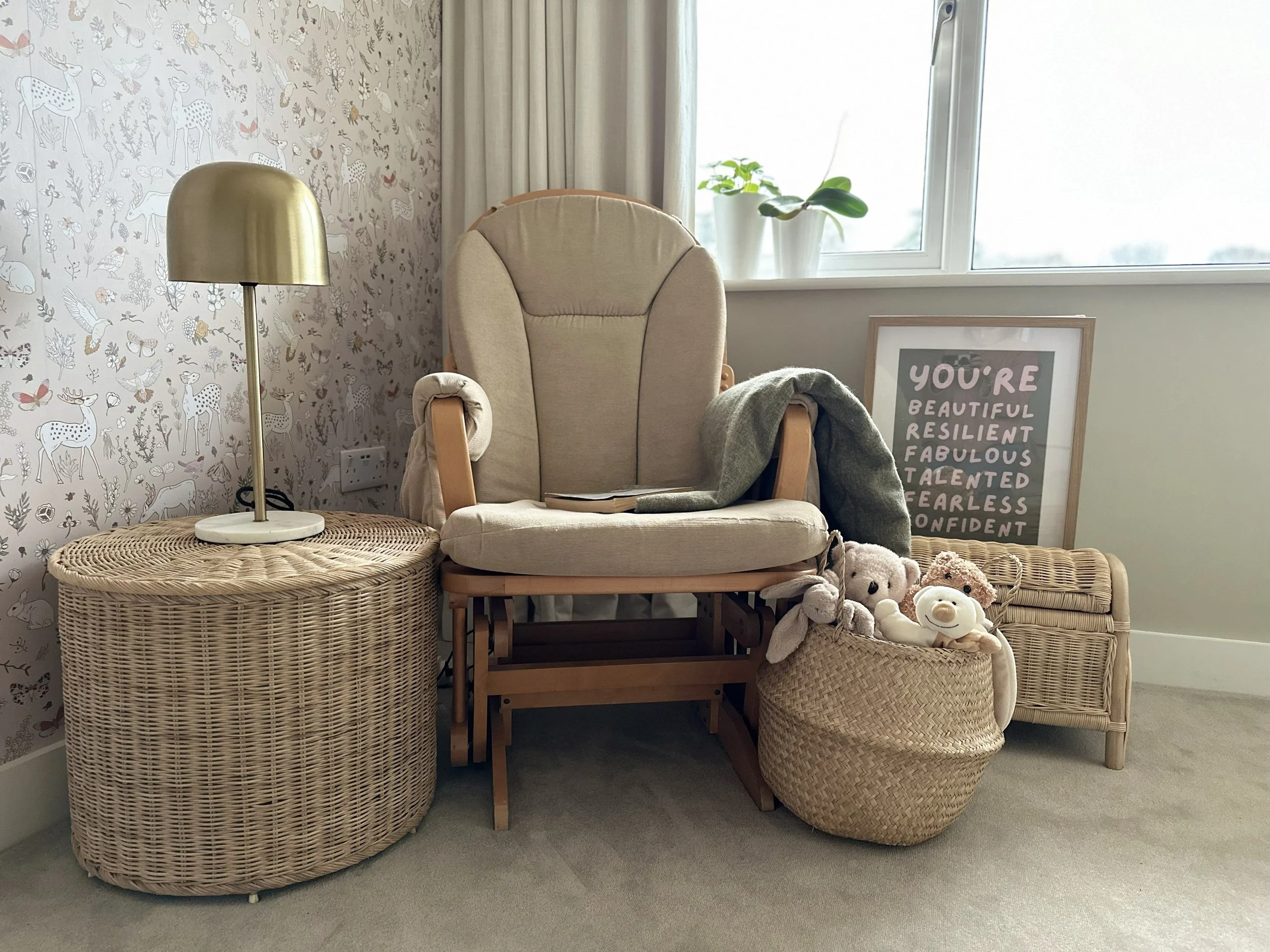 Cozy nursery corner with a comfortable nursing chair, woven textures and soft lighting designed for peaceful bonding moments.