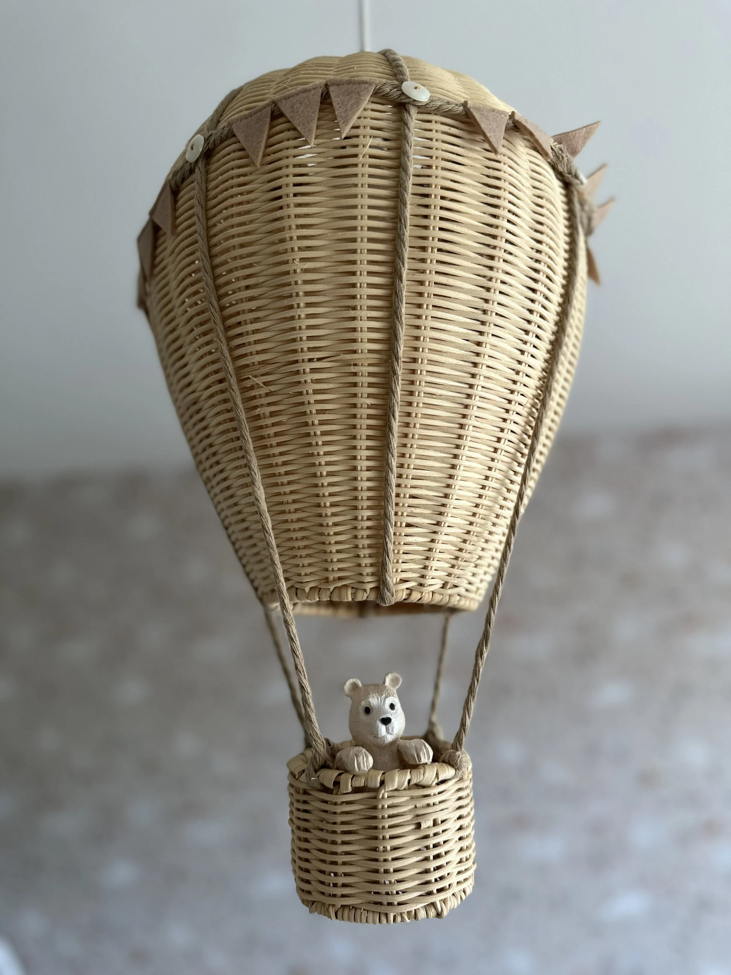 Handcrafted hot air balloon decor adding a playful and whimsical touch to this soft neutral nursery design.