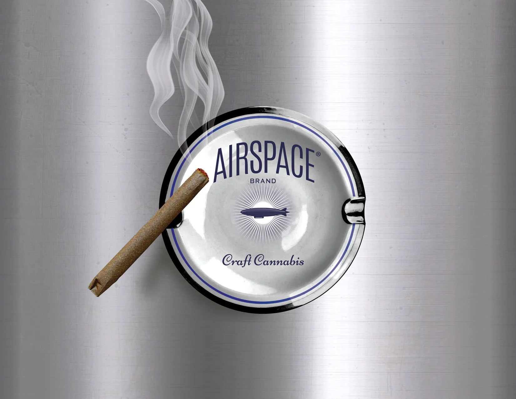 A can of Airspace craft cannabis with a lit joint placed on top of it, emitting smoke, on a metallic surface.