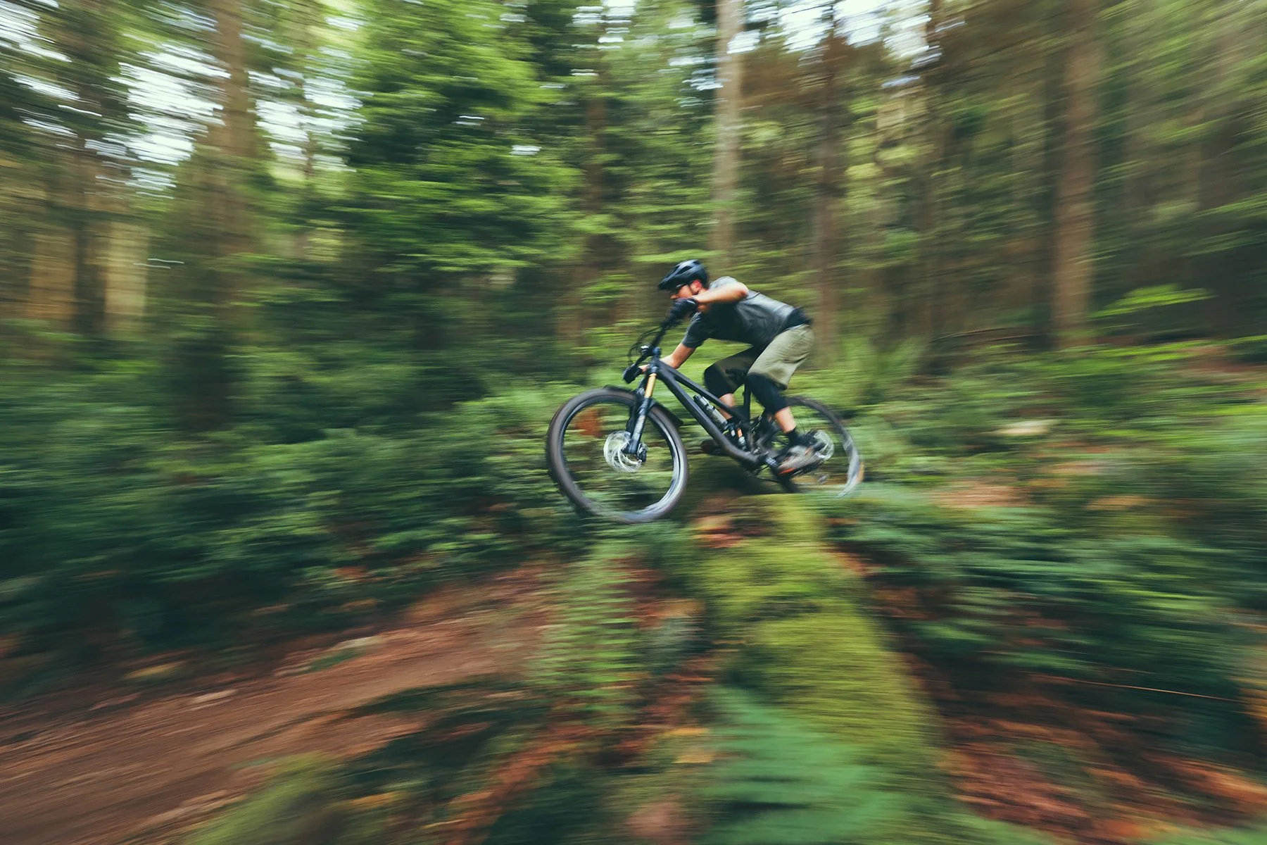 Blurry photo of biker racing through forest
