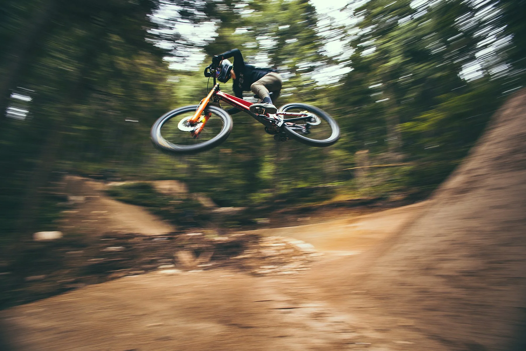 Blurry background biker racing over a jump