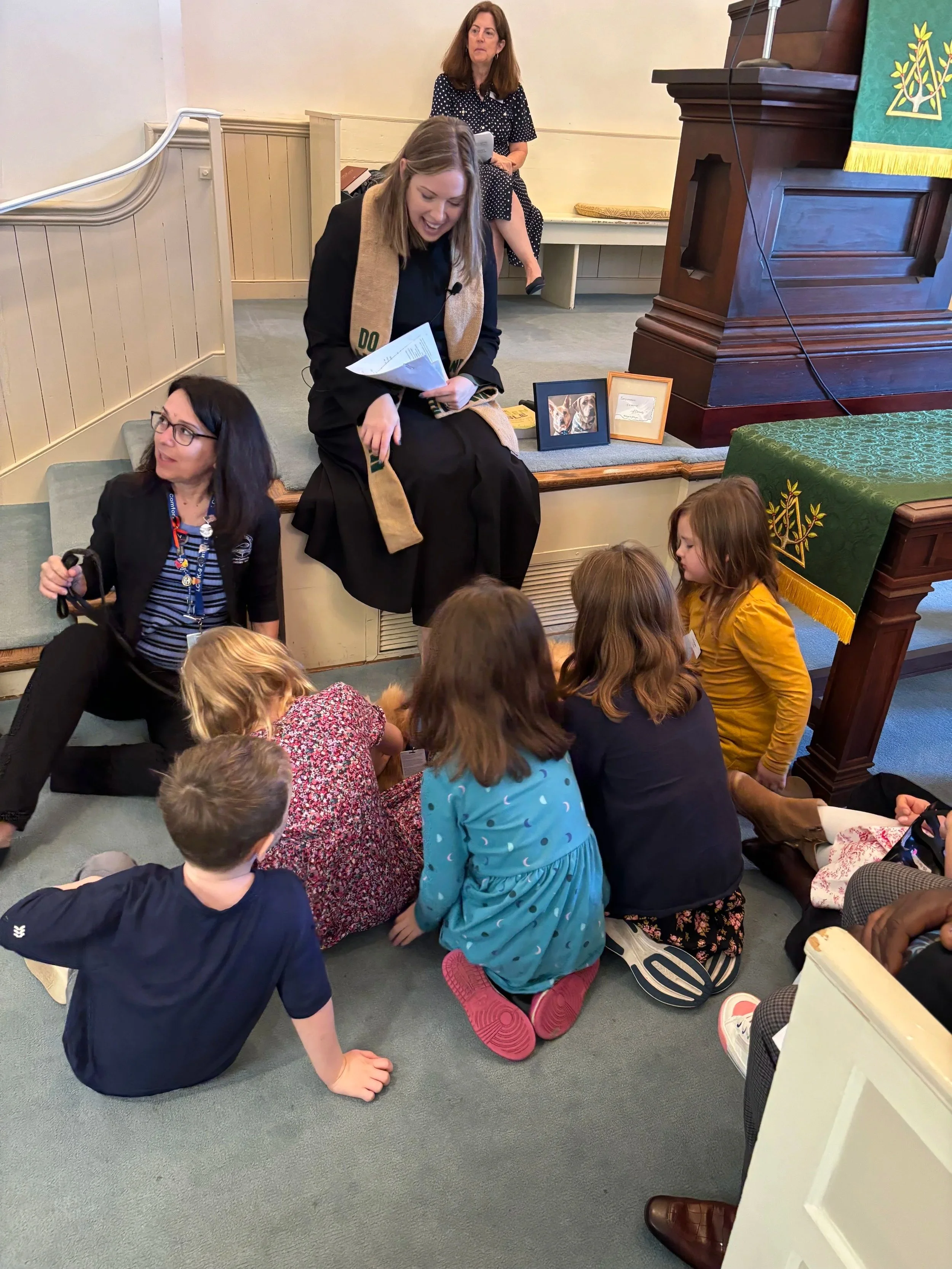 Two children sitting in a pew, looking at a hymnal