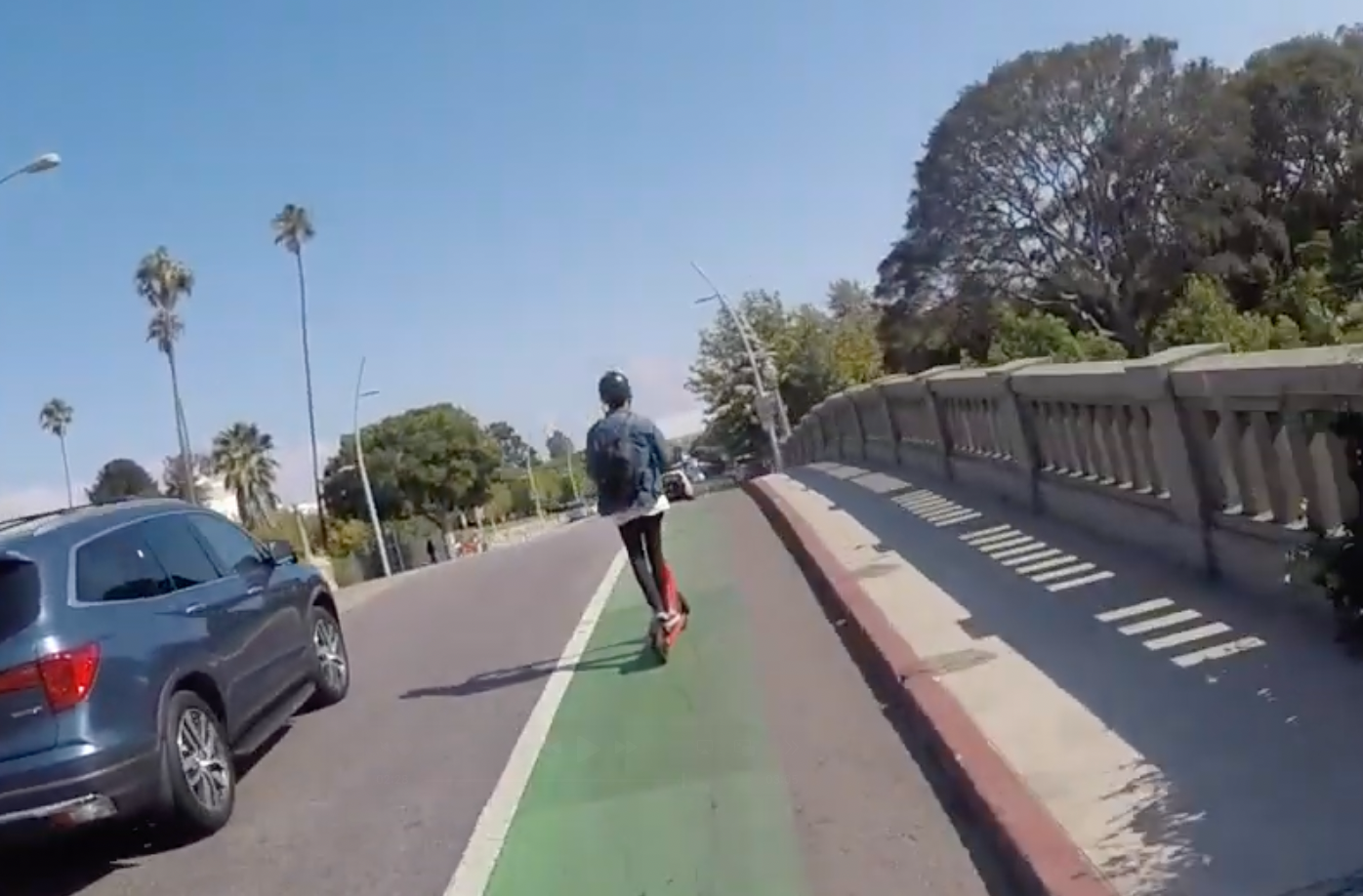 A person riding an electric scooter in a bike lane