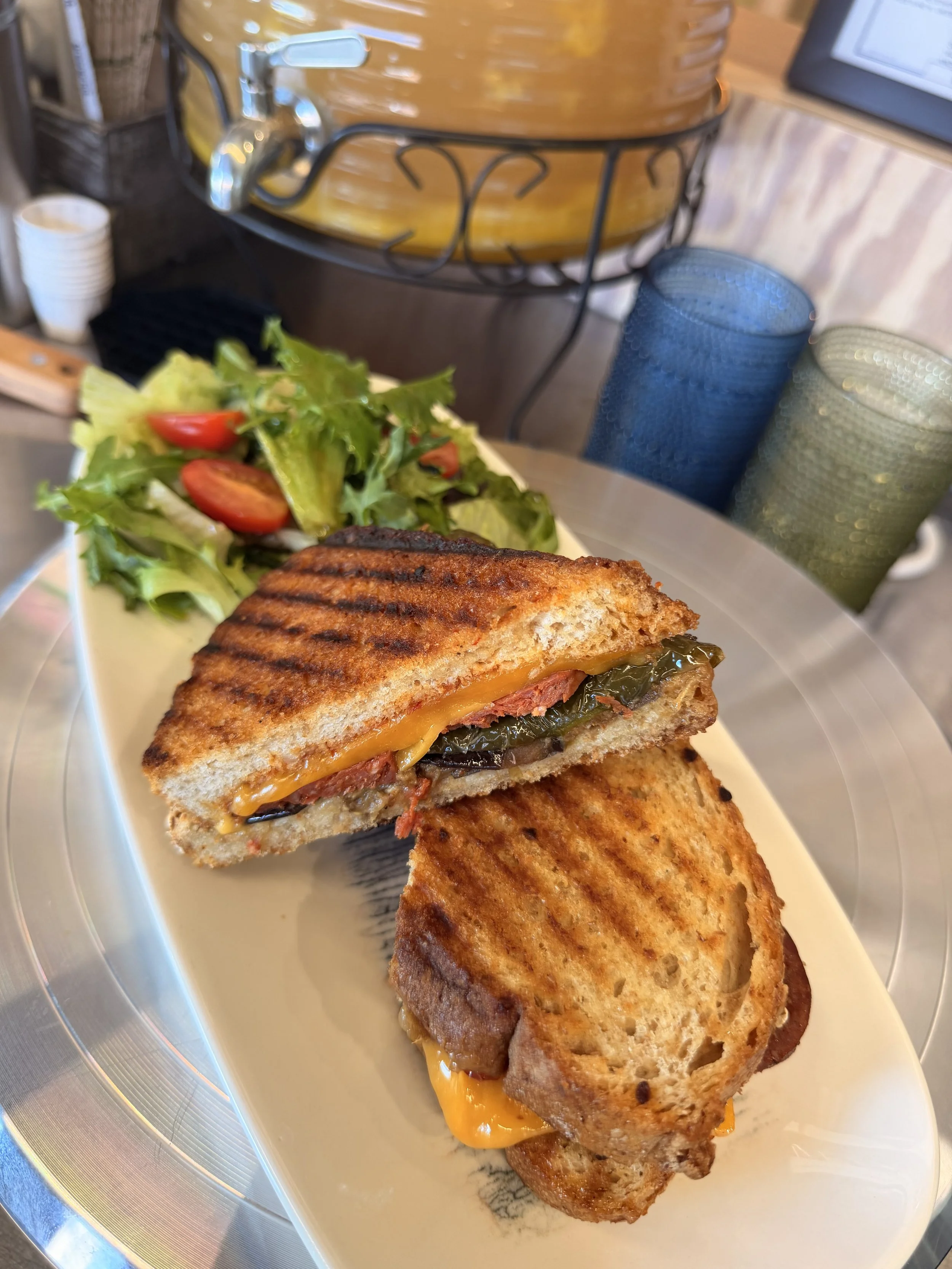 a plate of salad and panini