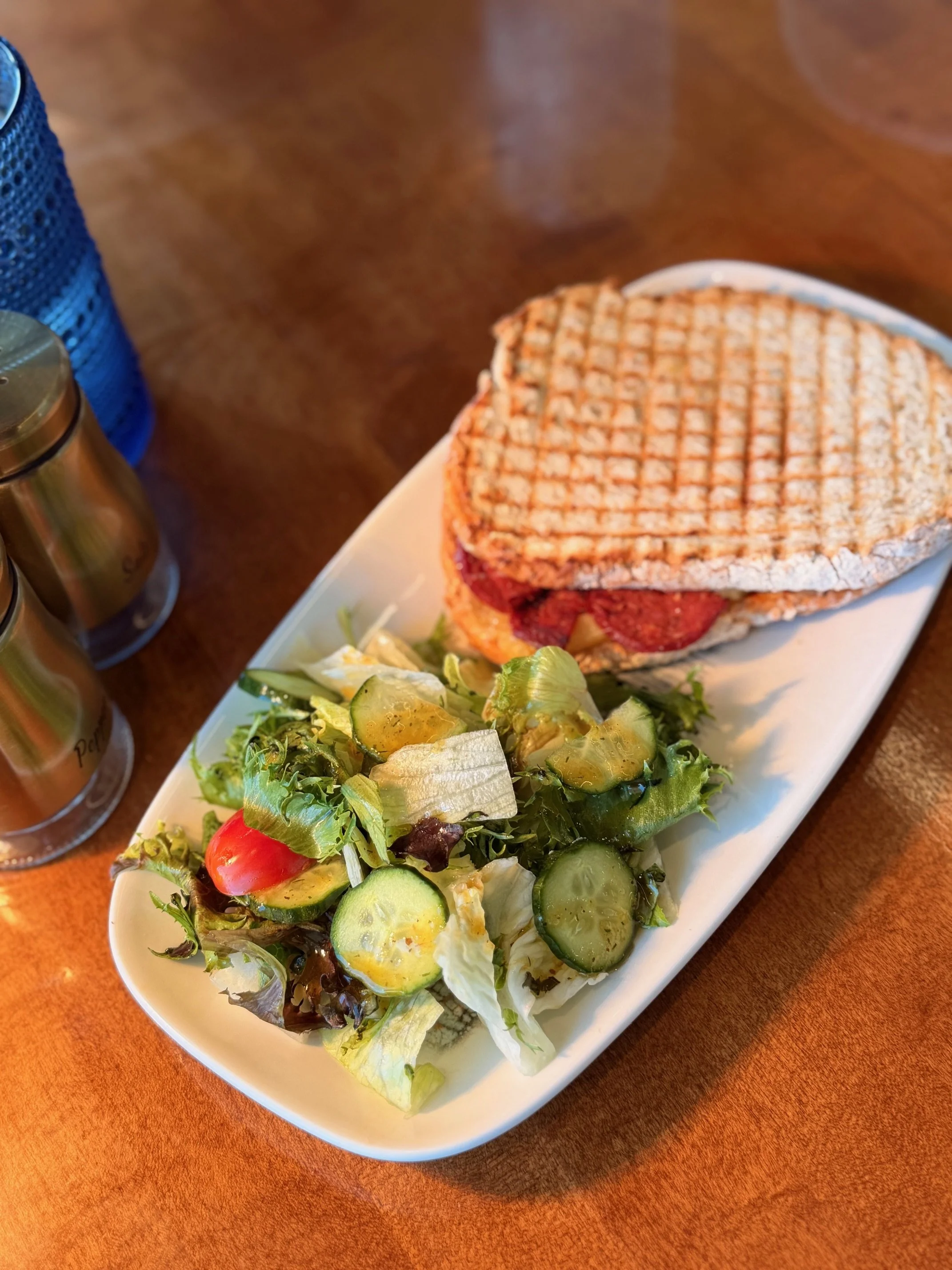 a plate of salad and panini