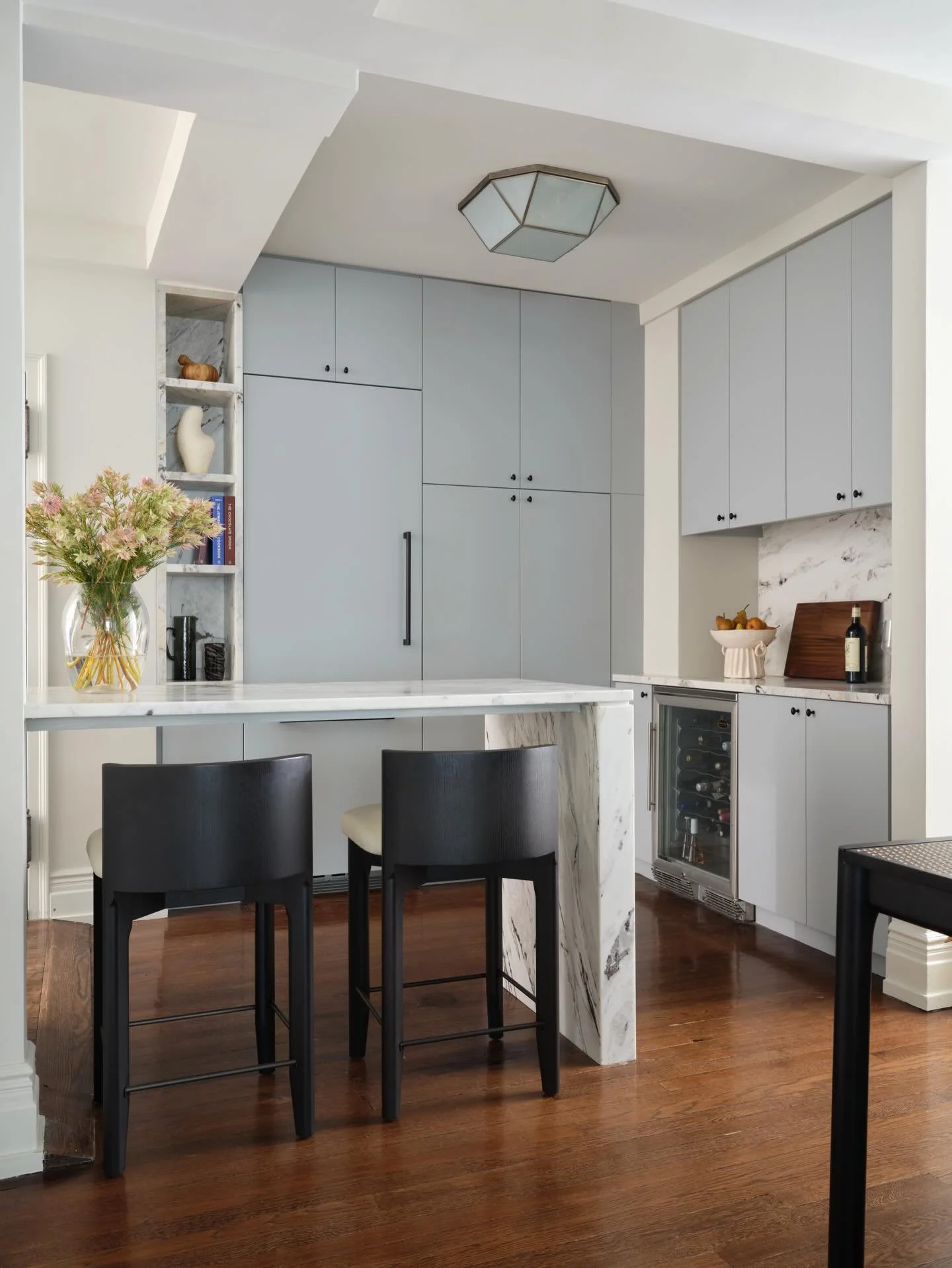 Powder blue paint, natural stone, and new lighting completely transformed the kitchen at our Gramercy project. Swipe to see where we started!