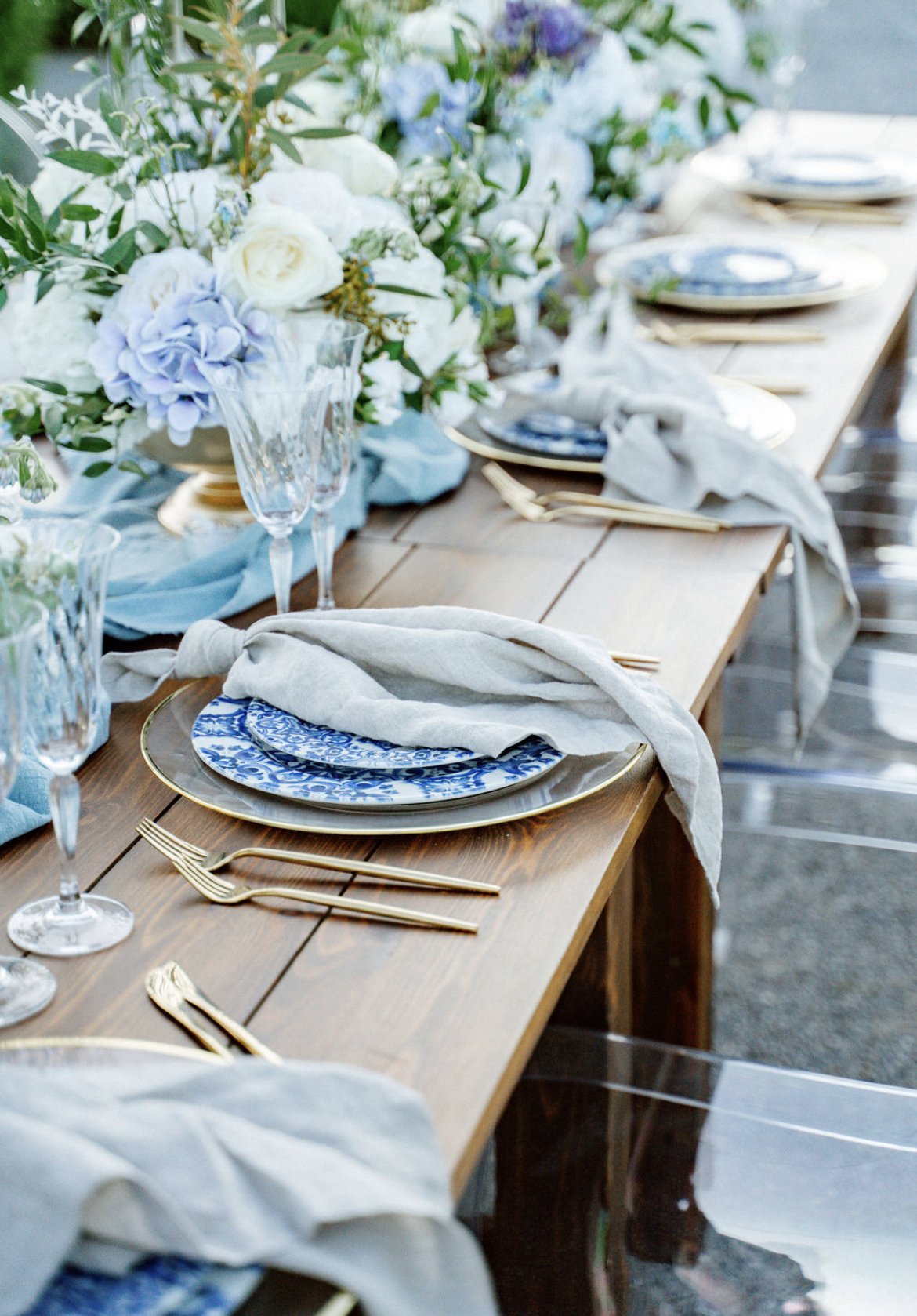 Tischdeko zur Hochzeit mit Blauen Blumen und Platztellern mit goldenem Besteck von de Waay