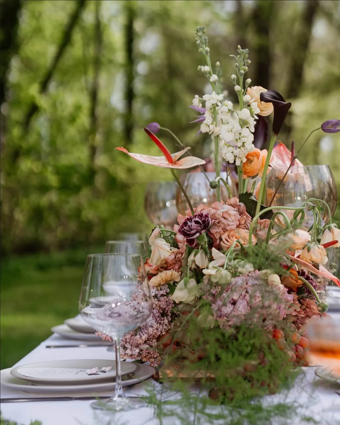 Lange Tafel mit frühlingshafter Tischdeko, zarter Floristik und viel Bewegung in der Tischmitte