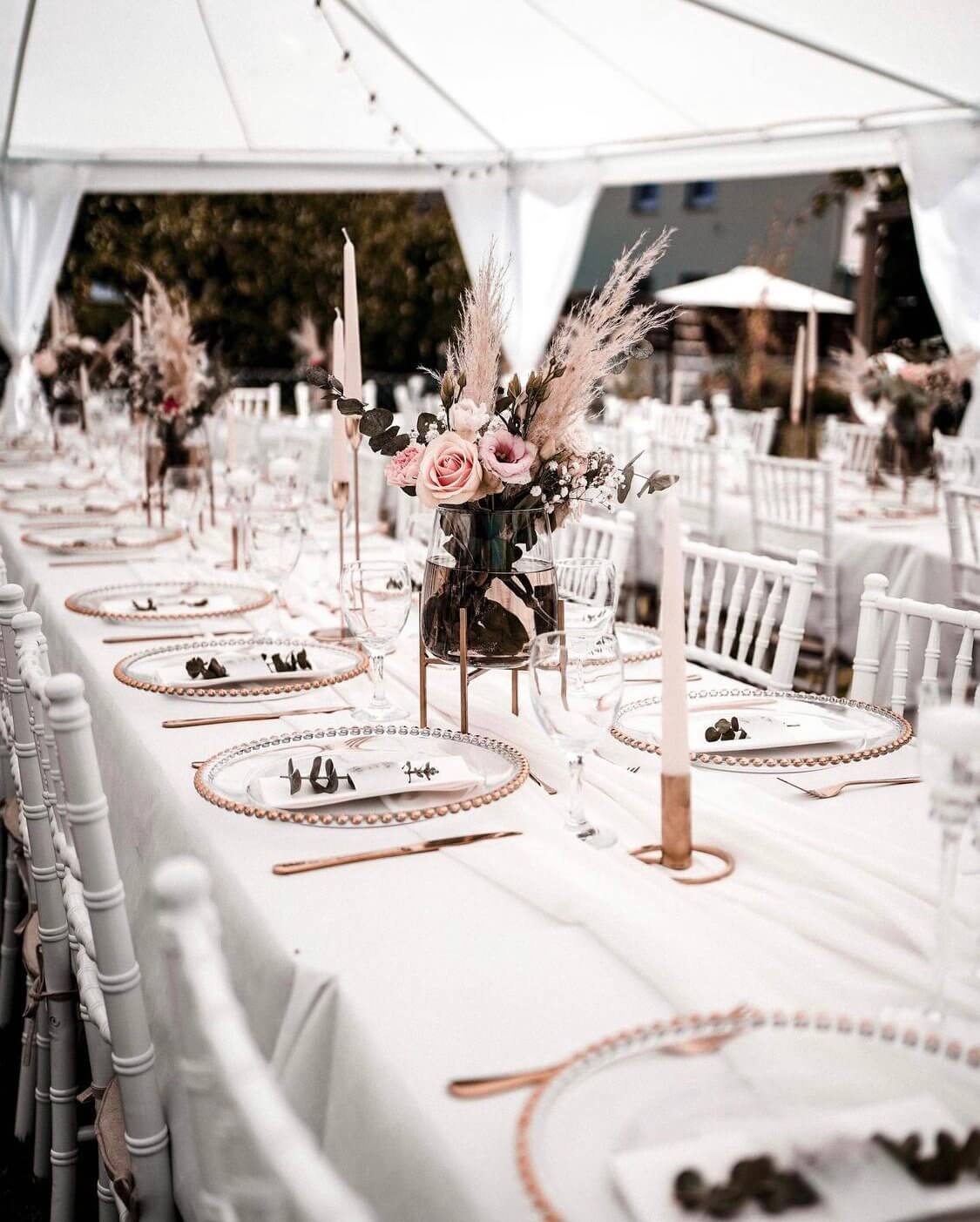 Strahlend weiße Zelthochzeit mit de Waay im White Pavilion Look mit weißen Tiffany Chairs, goldenen Platztellern, feinem Besteck und reduzierter Floristik – elegante Hochzeit im Zelt mit Schlossgefühl im Freien