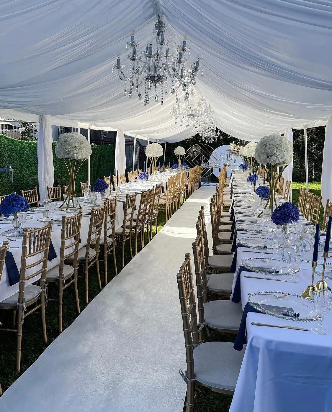 Elegante Zelthochzeit mit langer Tafel, weißem Zelt und Kronleuchtern – Beispiel für Gestaltungsfreiheit und Planungsaufwand einer Zelthochzeit