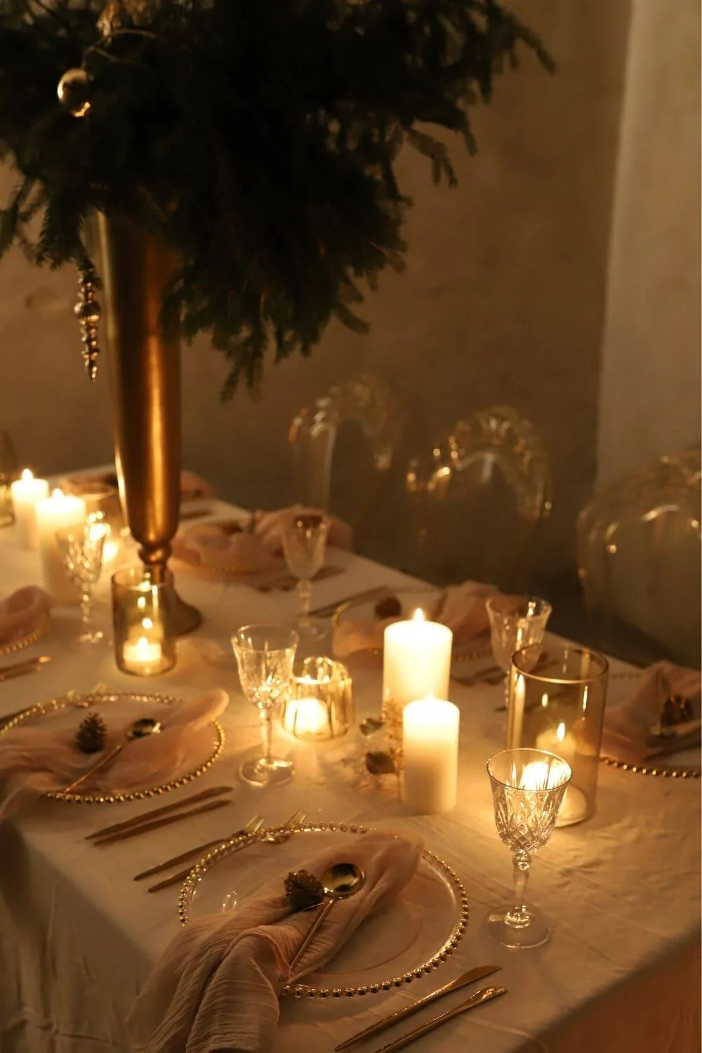 Moderne Tischdeko zu Weihnachten: Eleganter Weihnachtstisch mit goldenen Akzenten, Kerzenlicht und Kristallgläsern – moderne, stimmungsvolle Tischdeko im Look „Midnight Glow“ mit feinem Leinen und warmem Glanz.