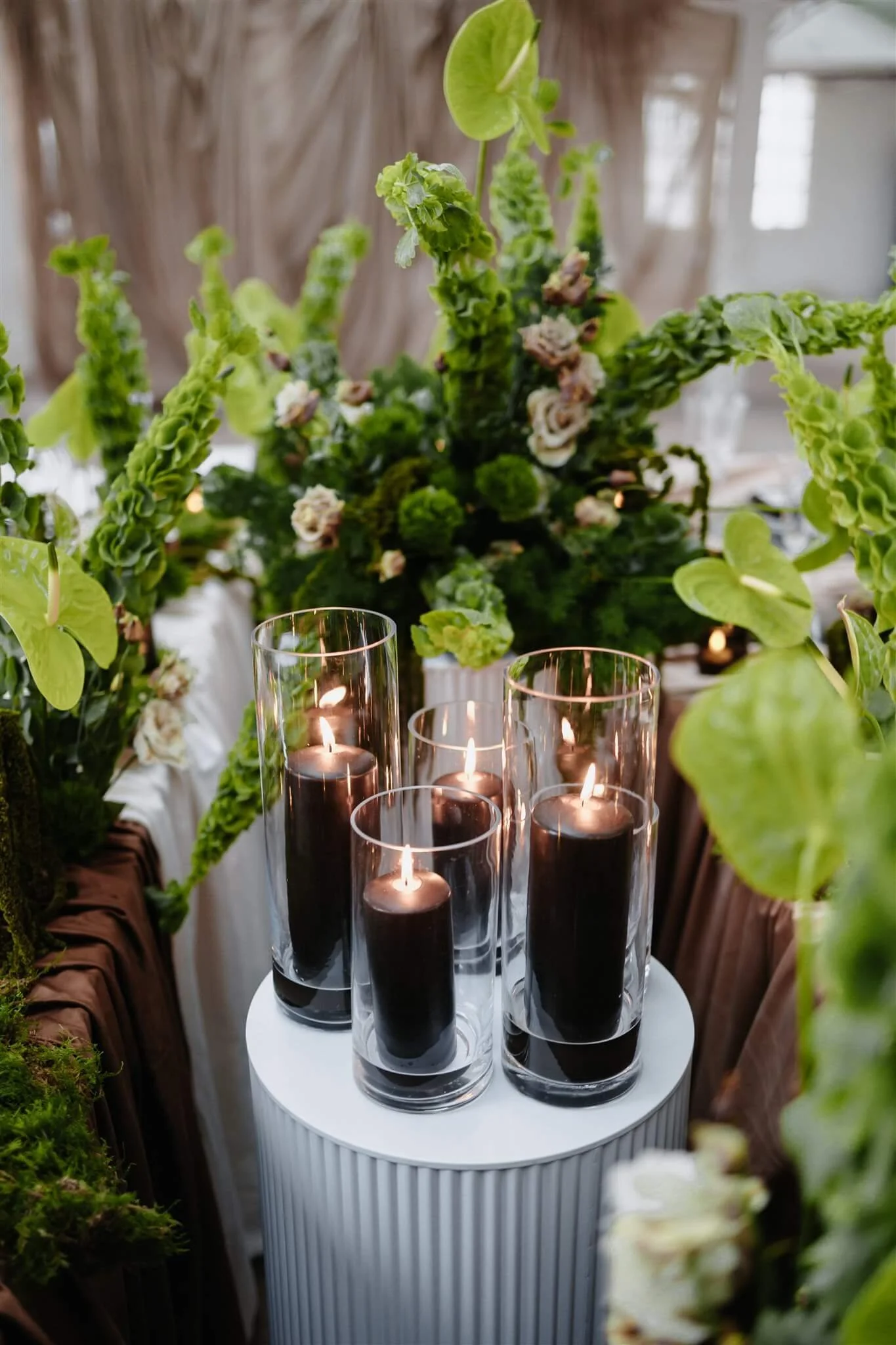 Hochzeitstafel von de Waay mit salbei- und olivgrüner Floristik, schwarzen Kerzen im Glas und gedämpften Grüntönen – erwachsene Hochzeitsfarben 2026