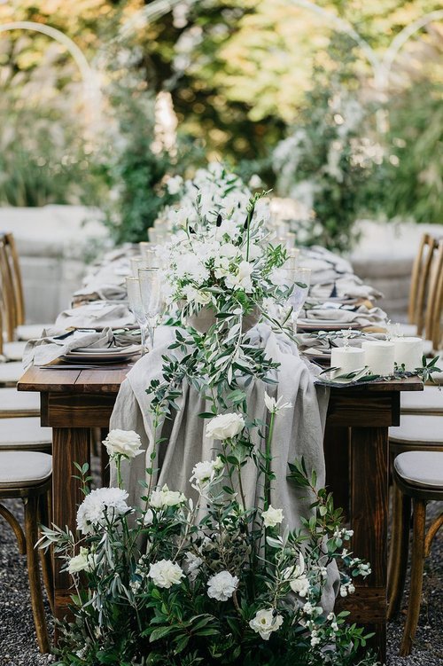Holztisch mieten für Outdoor-Hochzeit mit warmem Kerzenlicht & Naturdeko