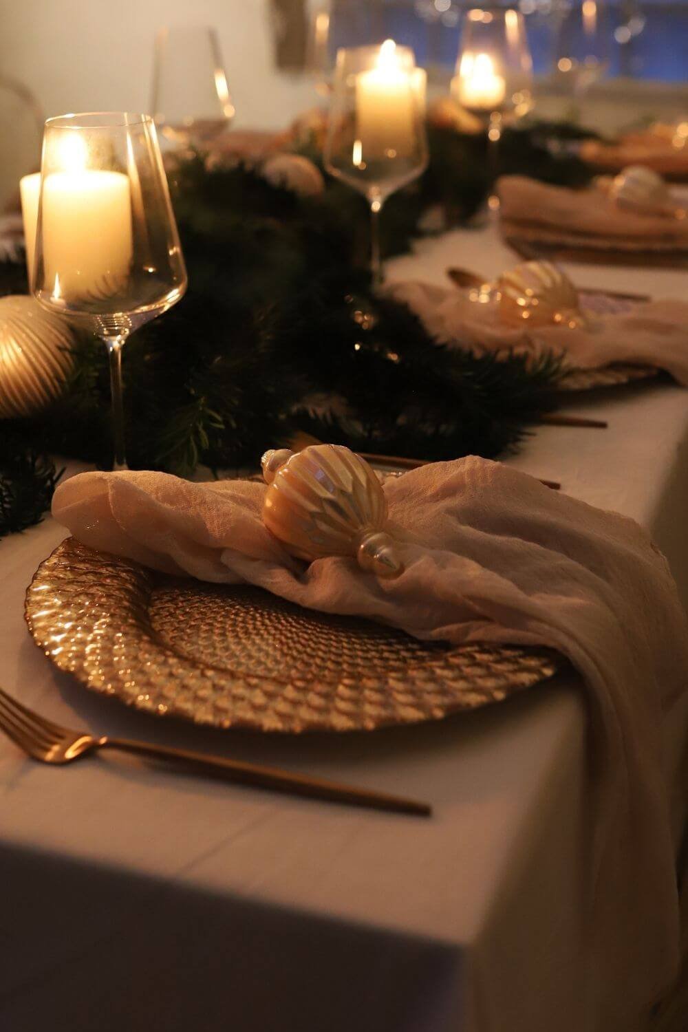 Moderner Weihnachtstisch mit Leinenservietten, goldfarbenem Besteck und Platzteller aus Glas – harmonischer Materialmix mit natürlicher Wirkung.
