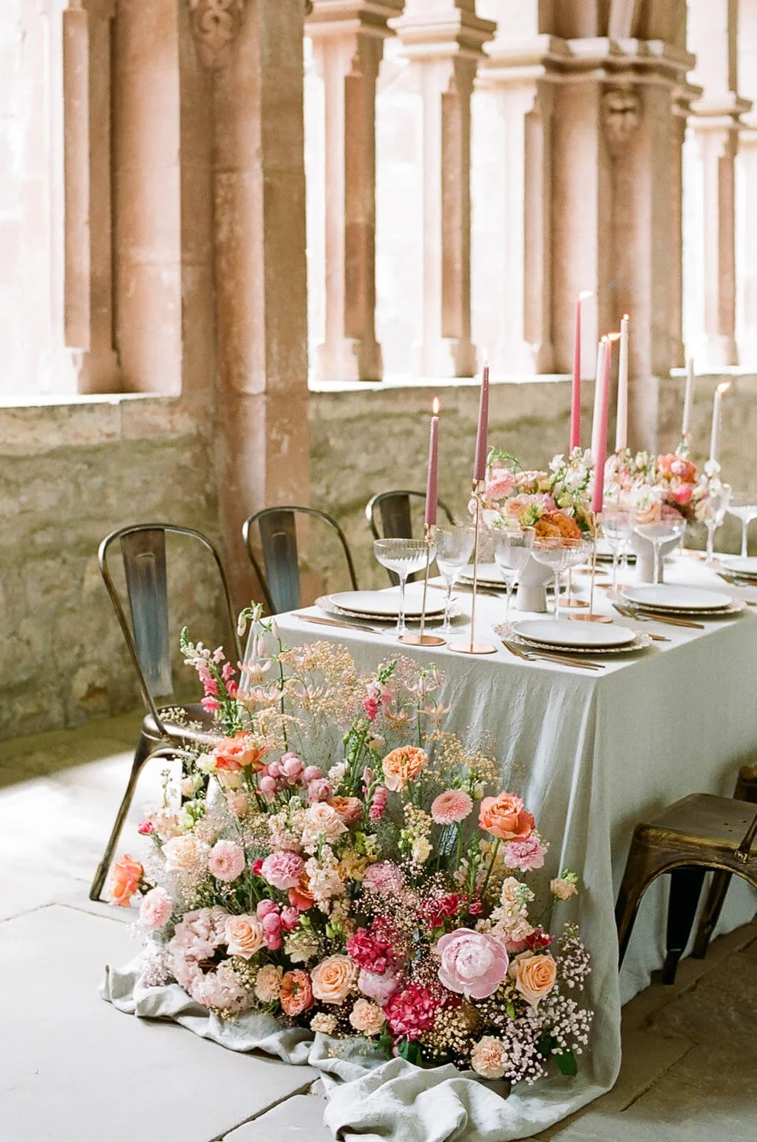 Elegante Hochzeitstafel von de Waay mit braunen Loft Stühlen und einer Floristik in Coral- und Apricottönen als moderne Hochzeitsfarben 2026