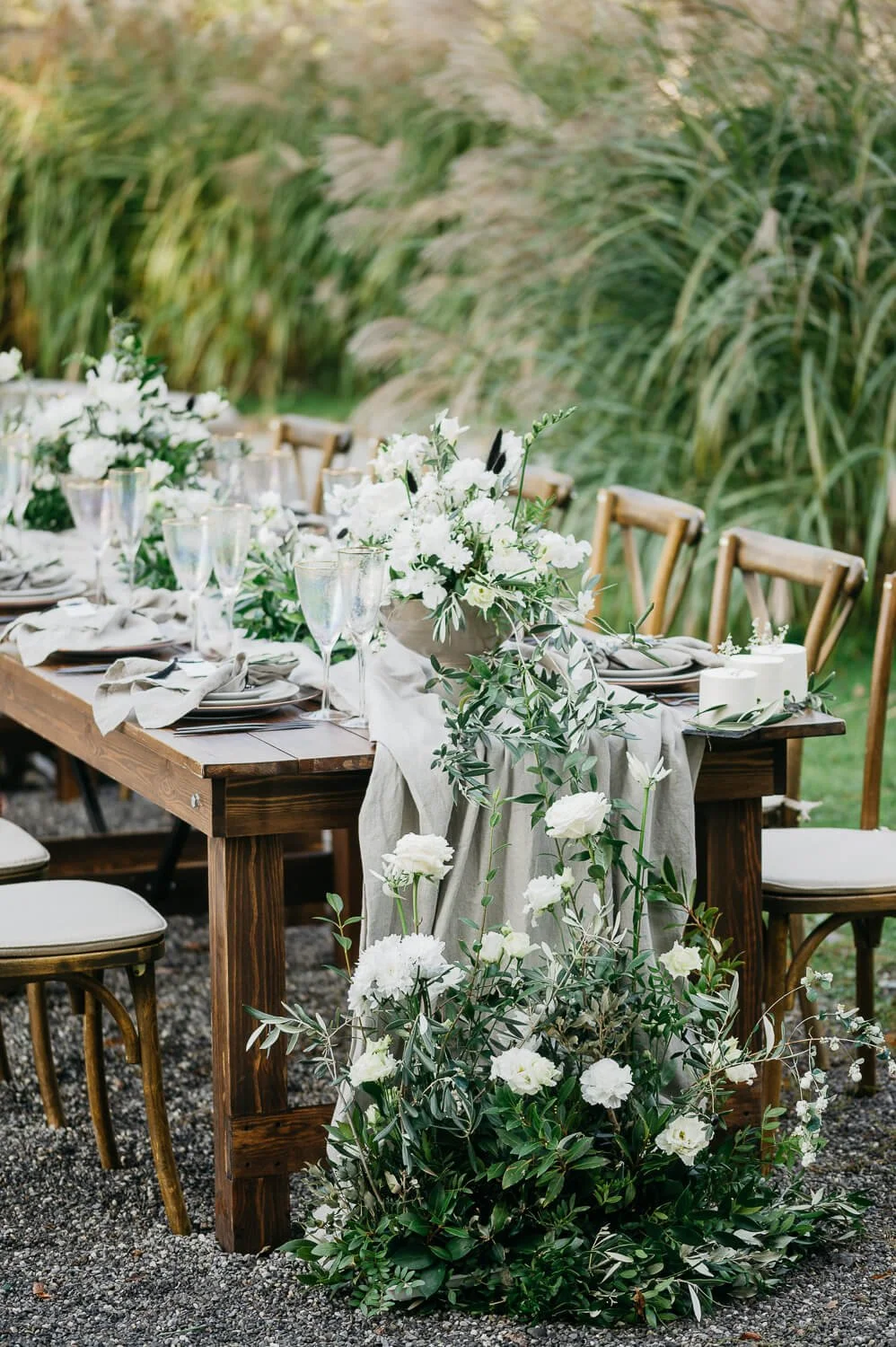 Holztisch bei einer Gartenhochzeit mit Farmer Table von de Waay und eleganter Tischdeko im Grünen