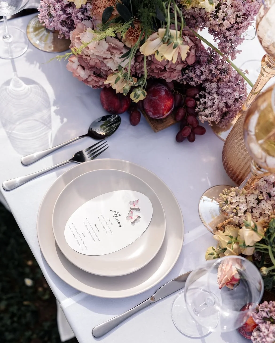 Frühlingshafte Tischdeko zur Hochzeit mit Glas, zarter Floristik und warmem Licht – Beispiel für leichte Hochzeitsdeko im Frühling