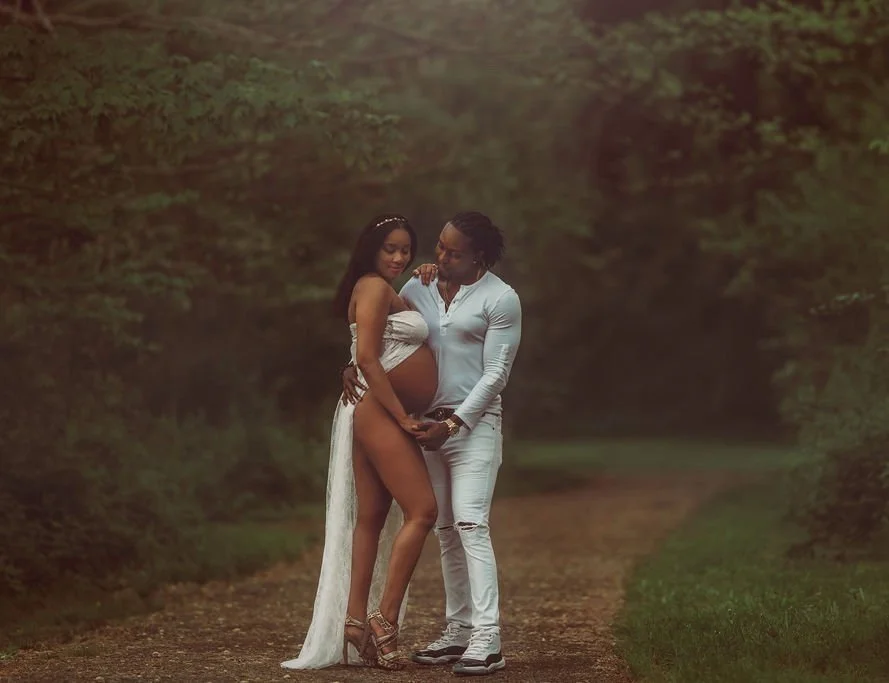 Expecting couple posing together in a forest area at Ridley Creek State Park during a maternity session
