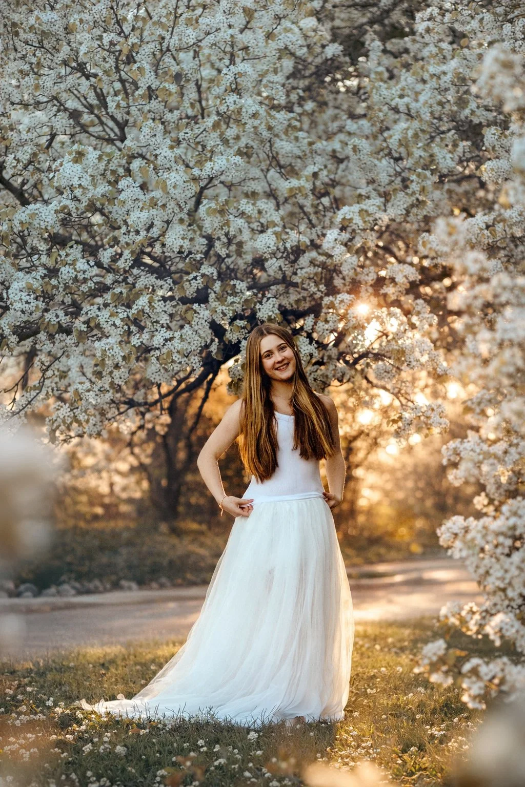 High school senior girl standing under pear blossom trees in Westville NJ during a soft spring portrait session