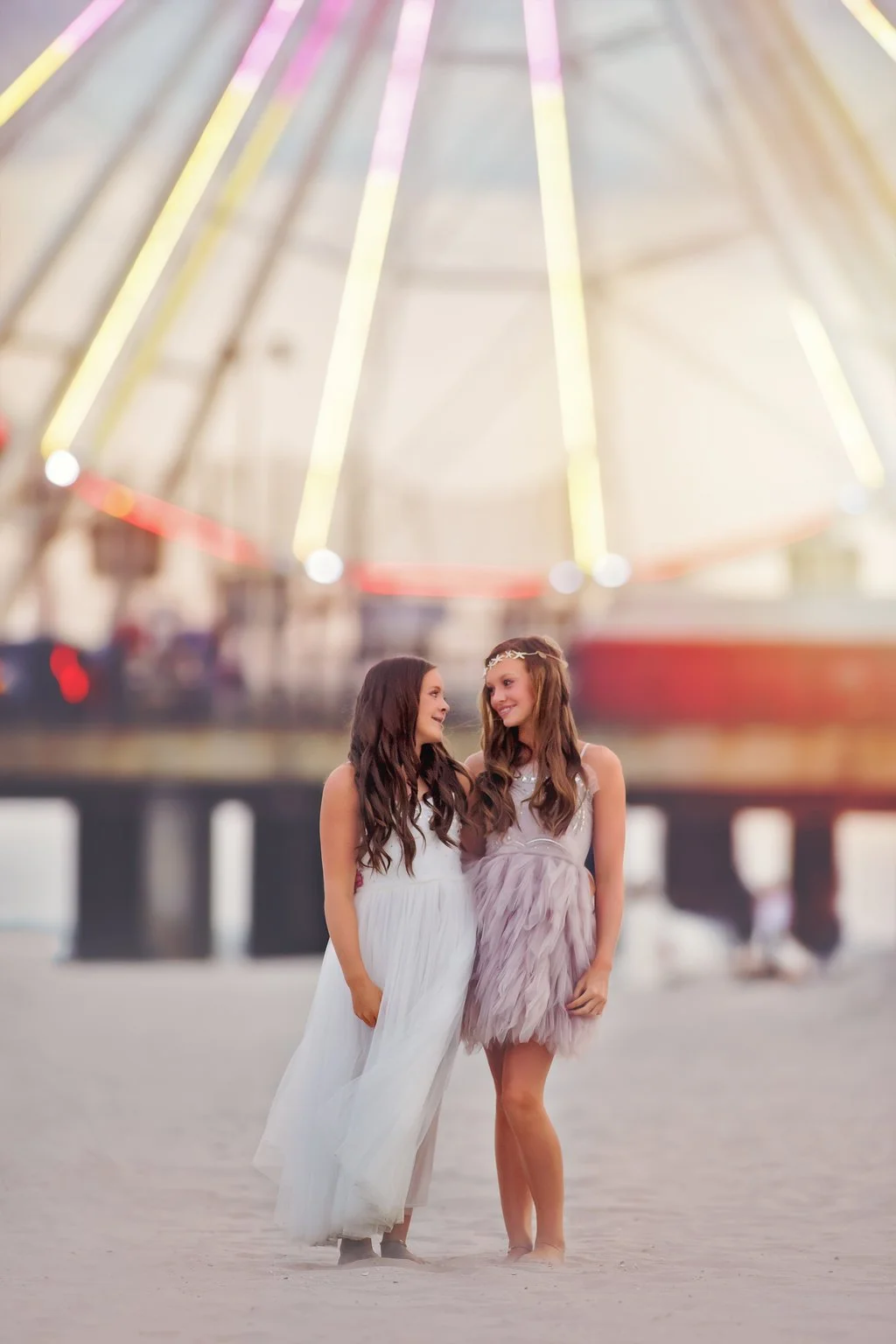 Two sisters sharing a quiet moment while looking at each other during a South Jersey family beach photography session at the Jersey Shore