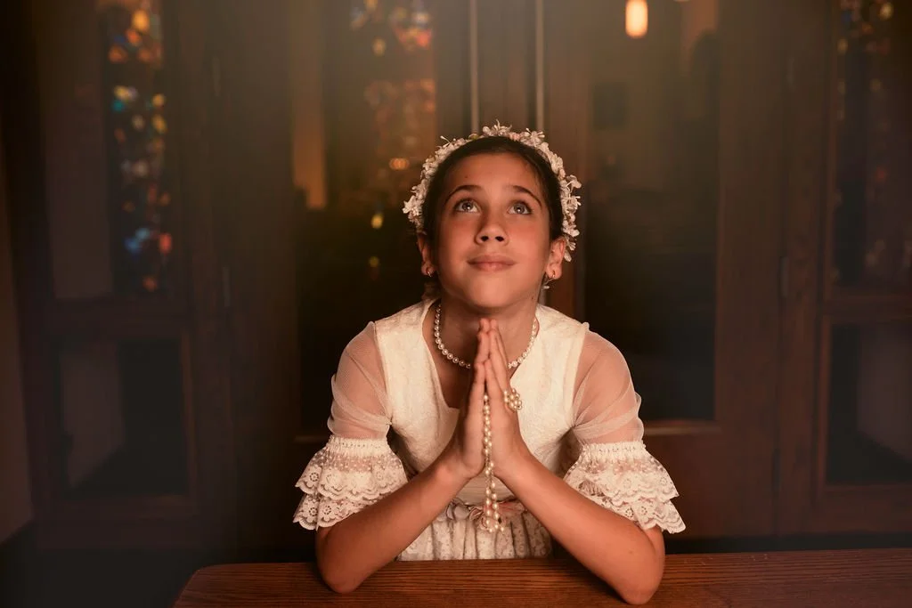 Close-up First Holy Communion portrait showing a young girl holding her rosary during her Communion session