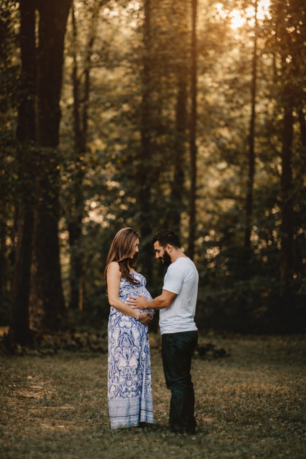 Pregnant woman and partner standing together outdoors during an intimate maternity photography session