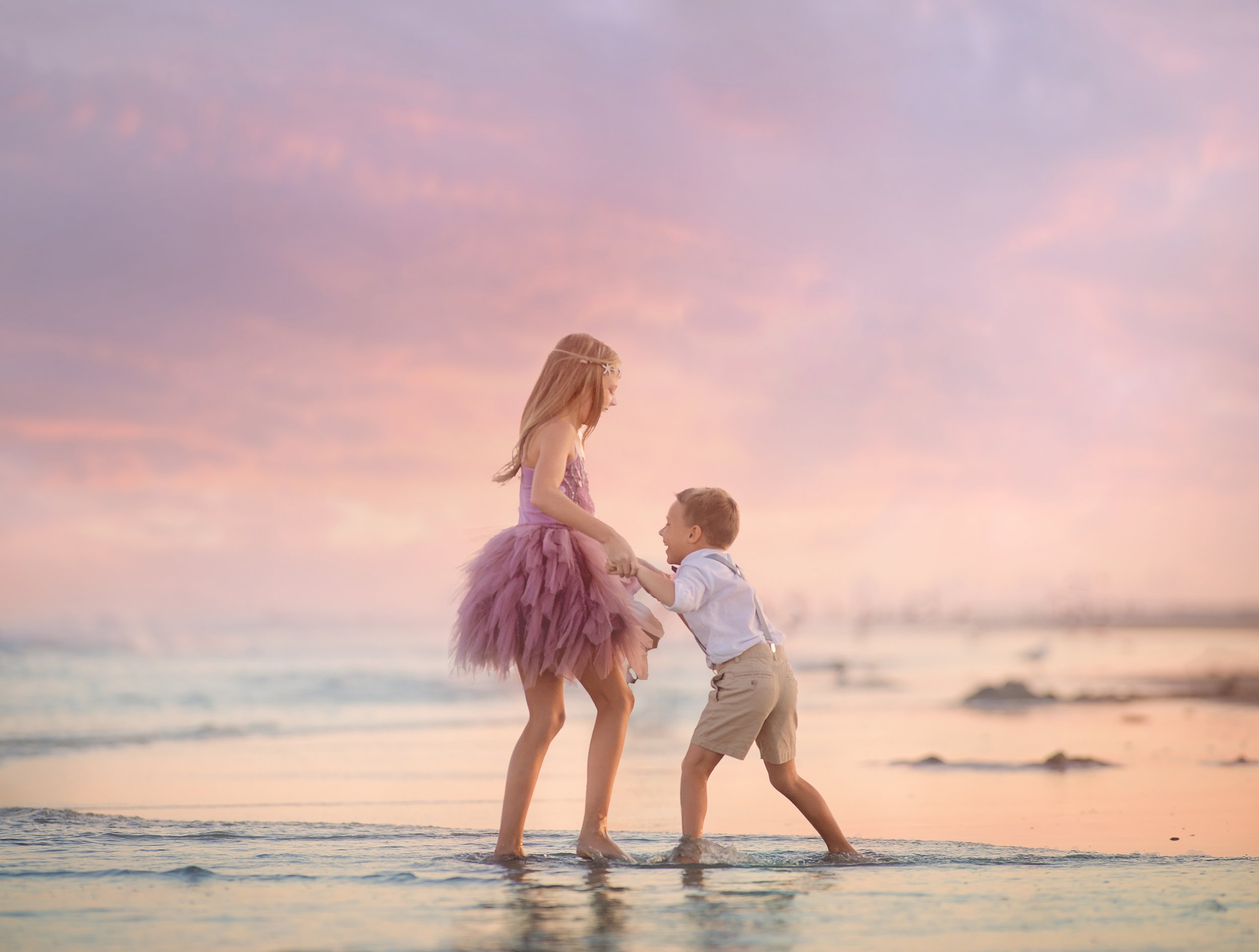 Brother and sister playing in the sand during a beach photography session in Wildwood NJ captured by a South Jersey photographer.