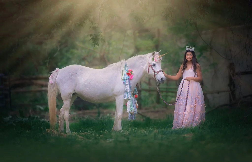Girl smiling with a unicorn during a magical birthday photoshoot in Mullica Hill New Jersey photographed by a South Jersey unicorn photographer.