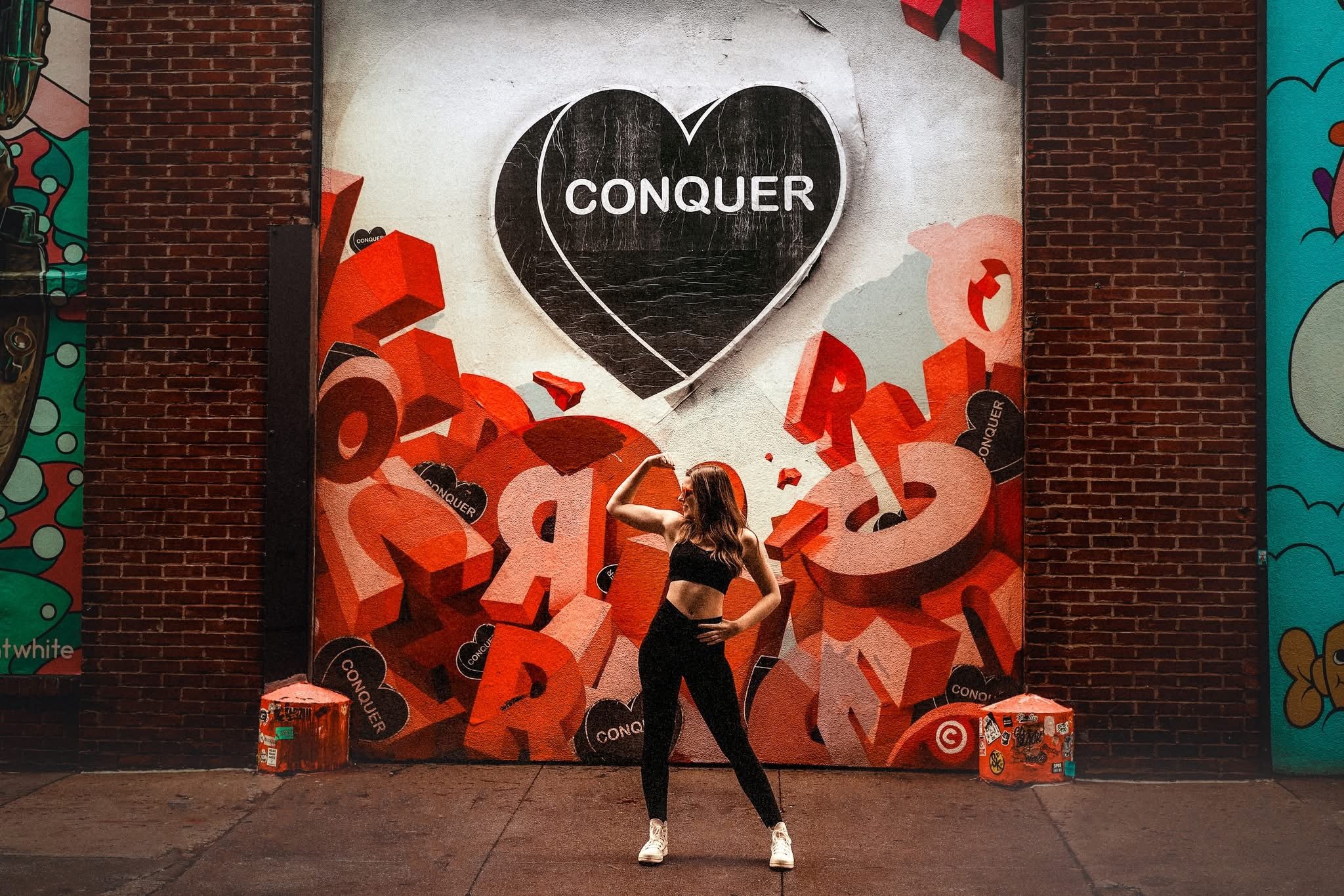 Teen portrait in front of bold graffiti under the El, blending urban texture and modern style in Philadelphia.