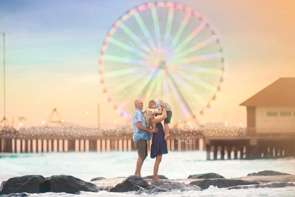 Mom, dad, and son during a family portrait session near the Ferris wheel in Atlantic City, New Jersey.