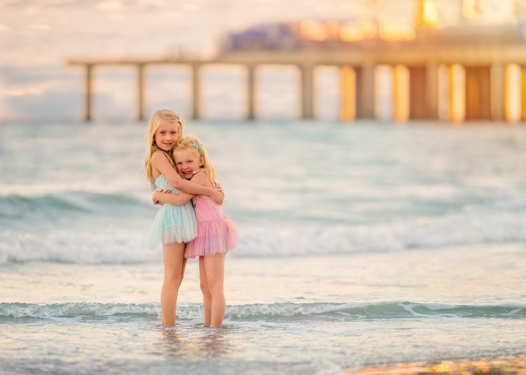 Two sisters hugging during a beach portrait session in Ocean City, NJ.