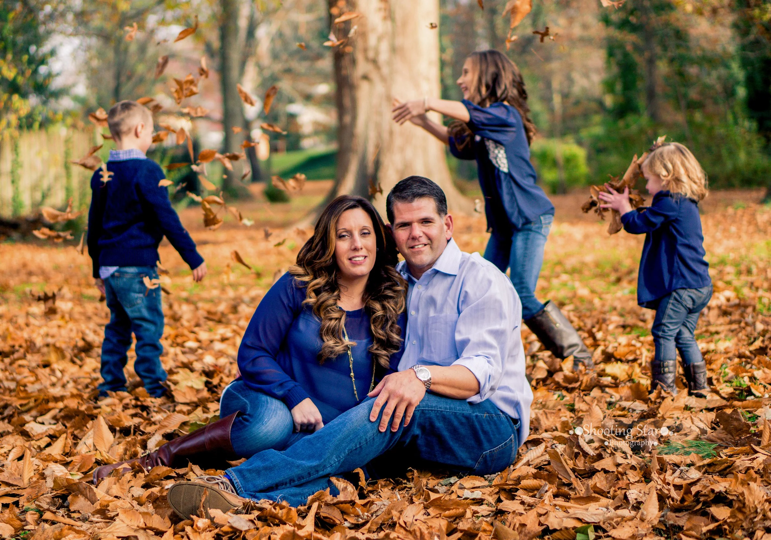 Family playing together in fall leaves in Salem County, New Jersey.