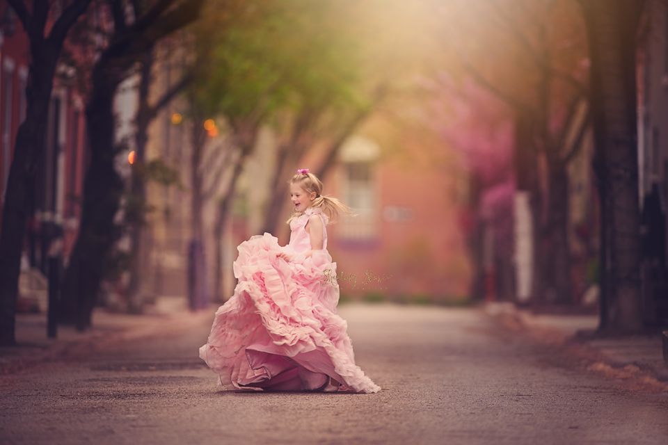 Fine art children's portrait of a young girl in a flowing pink dress photographed outdoors in New Jersey, creating a dreamy and timeless storybook feel