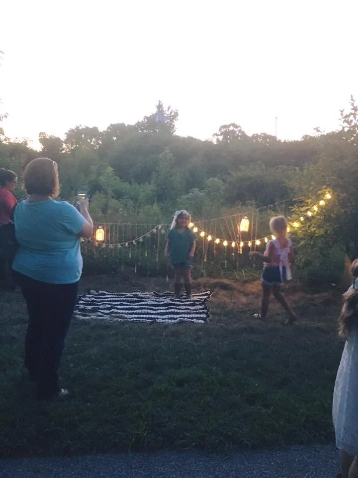 Behind-the-scenes view of a family photographer guiding poses during a boho-style evening photo session in South Jersey