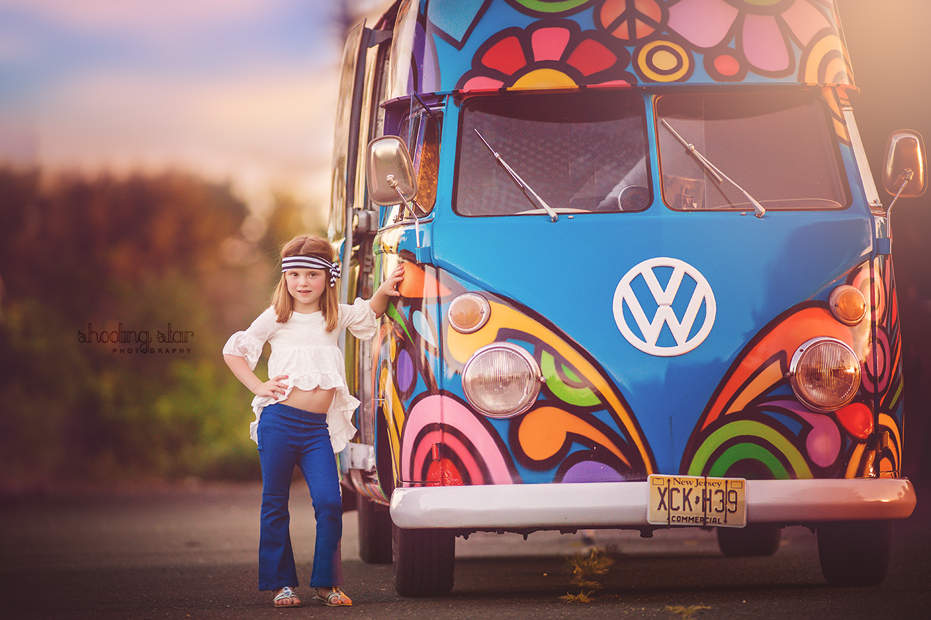 Little girl wearing hippie-inspired attire posing beside a vintage VW bus during a nostalgic photo session in South Jersey