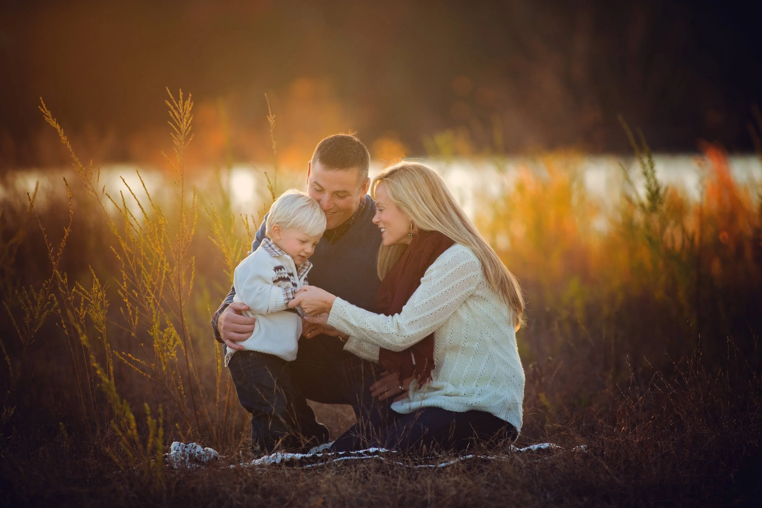 Parents and child enjoying a picnic during a relaxed family portrait session near Lake Audrey in Millville NJ.