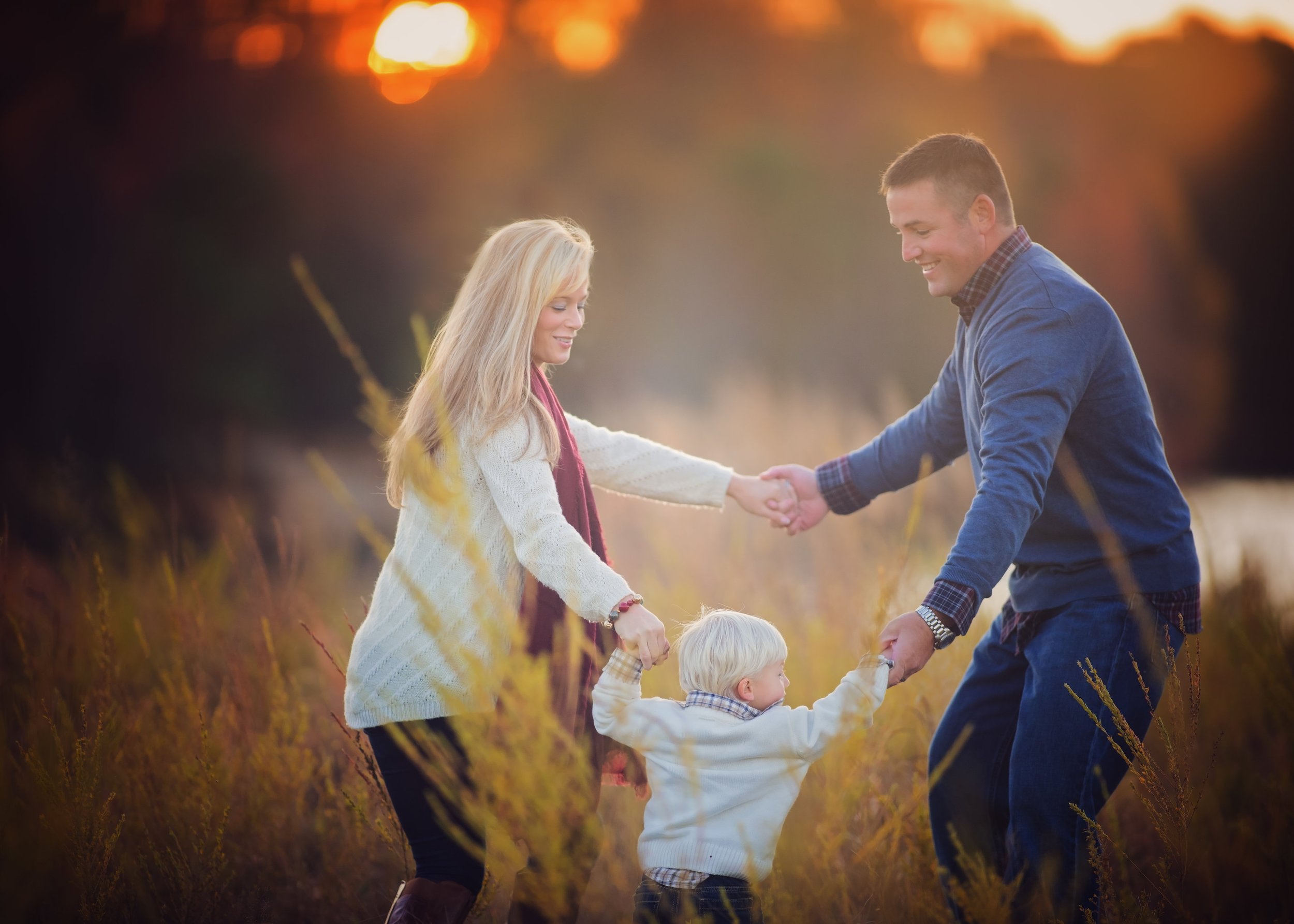 Family playing ring around the rosie together during a family photography session in Millville New Jersey captured by a South Jersey family photographer.