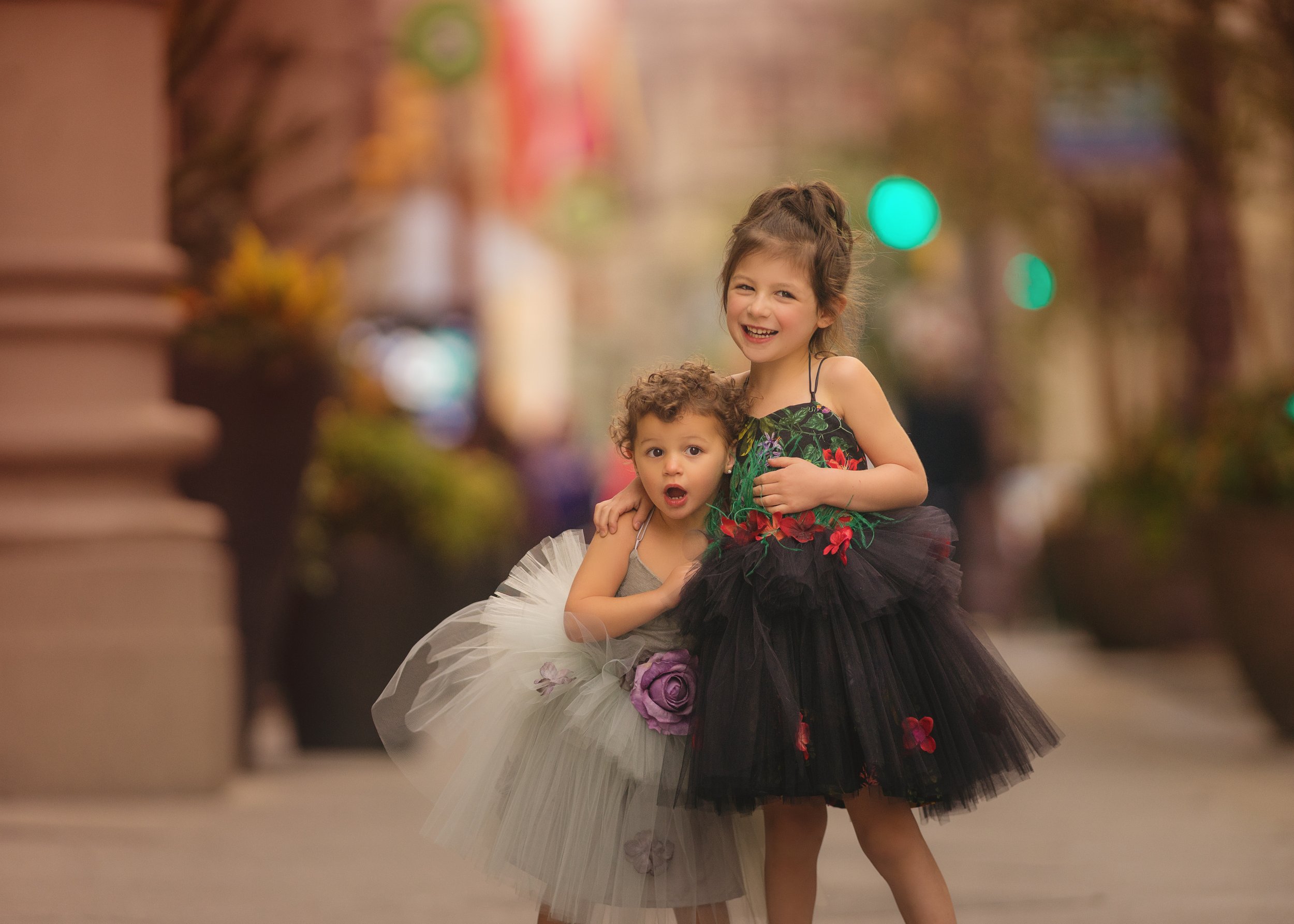 Two sisters smiling together in dresses during family portrait session in Philadelphia