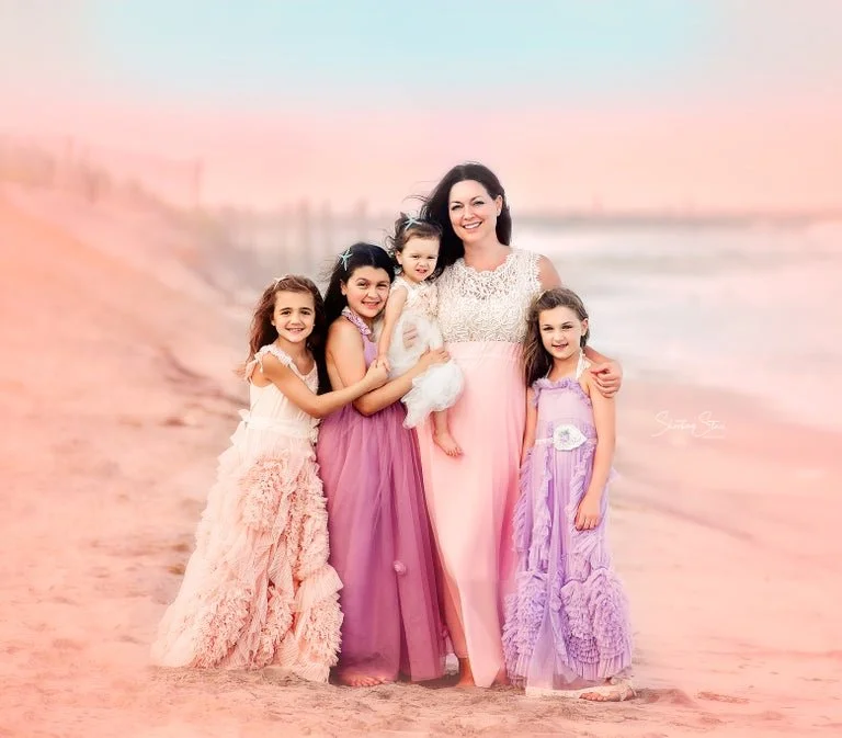 Mother smiling with her children on the beach during a golden hour family photography session on the Jersey Shore