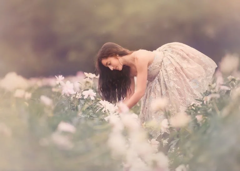 Teen girl picking peonies in South Jersey flower field during portrait session