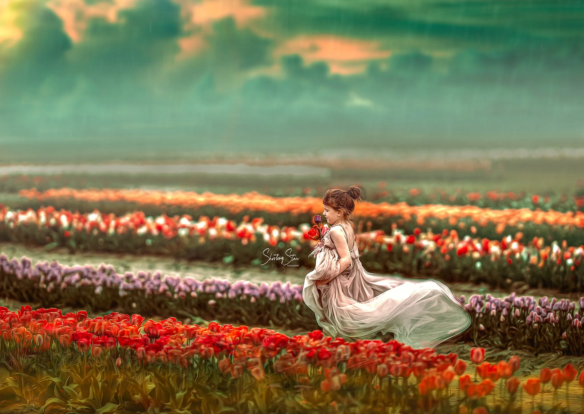 Girl in a gray dress running through a tulip field in New Jersey during a spring portrait session
