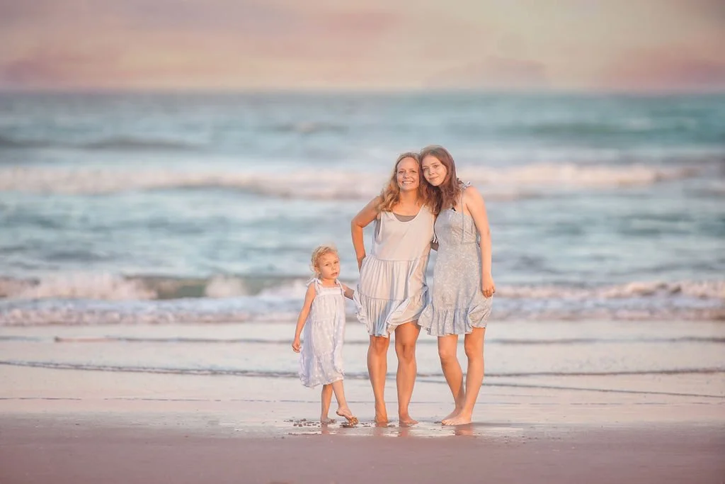 Mother and two daughters standing by the ocean water at Wildwood beach in New Jersey during sunset portraits